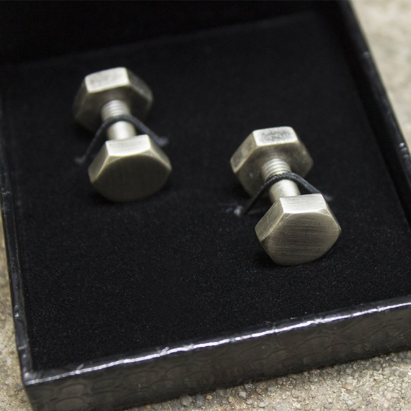 Agonal Screw Cufflinks made of stainless steel with a rhodium plated finish, featuring a unique screw design, presented in a stylish gift box.