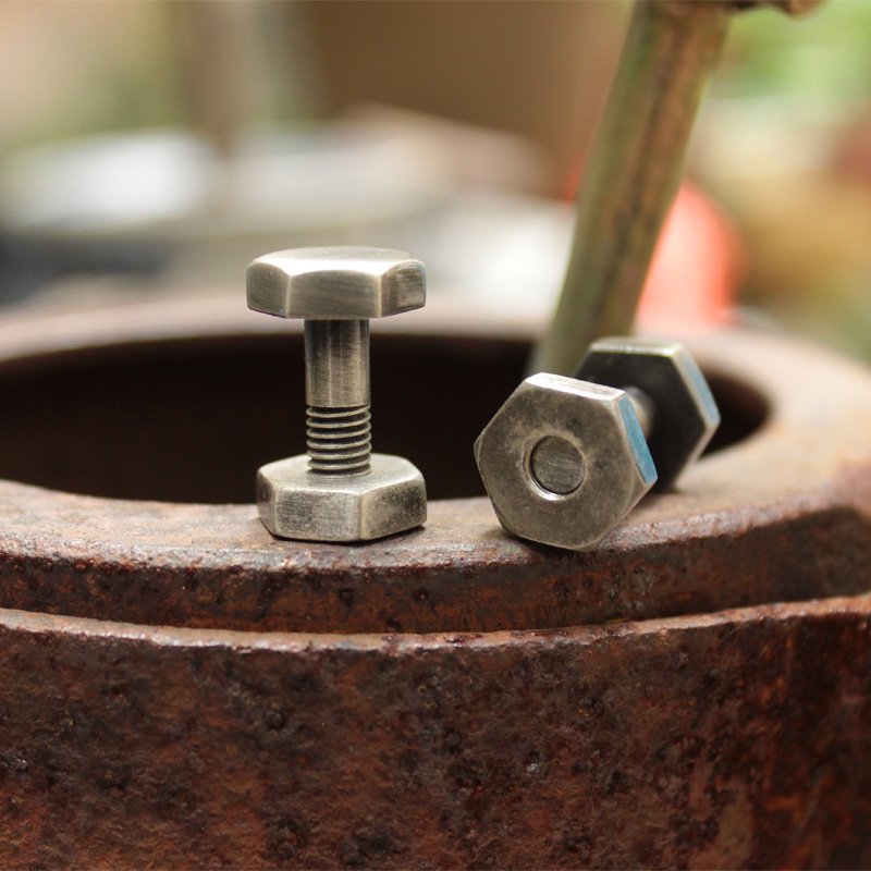 Agonal Screw Cufflinks made of stainless steel with a rhodium plated finish, featuring a unique screw design, presented in a stylish gift box.