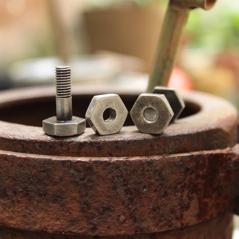 Agonal Screw Cufflinks made of stainless steel with a rhodium plated finish, featuring a unique screw design, presented in a stylish gift box.