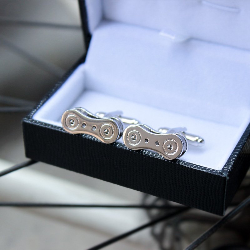 Stylish bike chain cufflinks made from titanium alloy, featuring a unique design perfect for french cuff shirts, presented in a luxurious gift box.