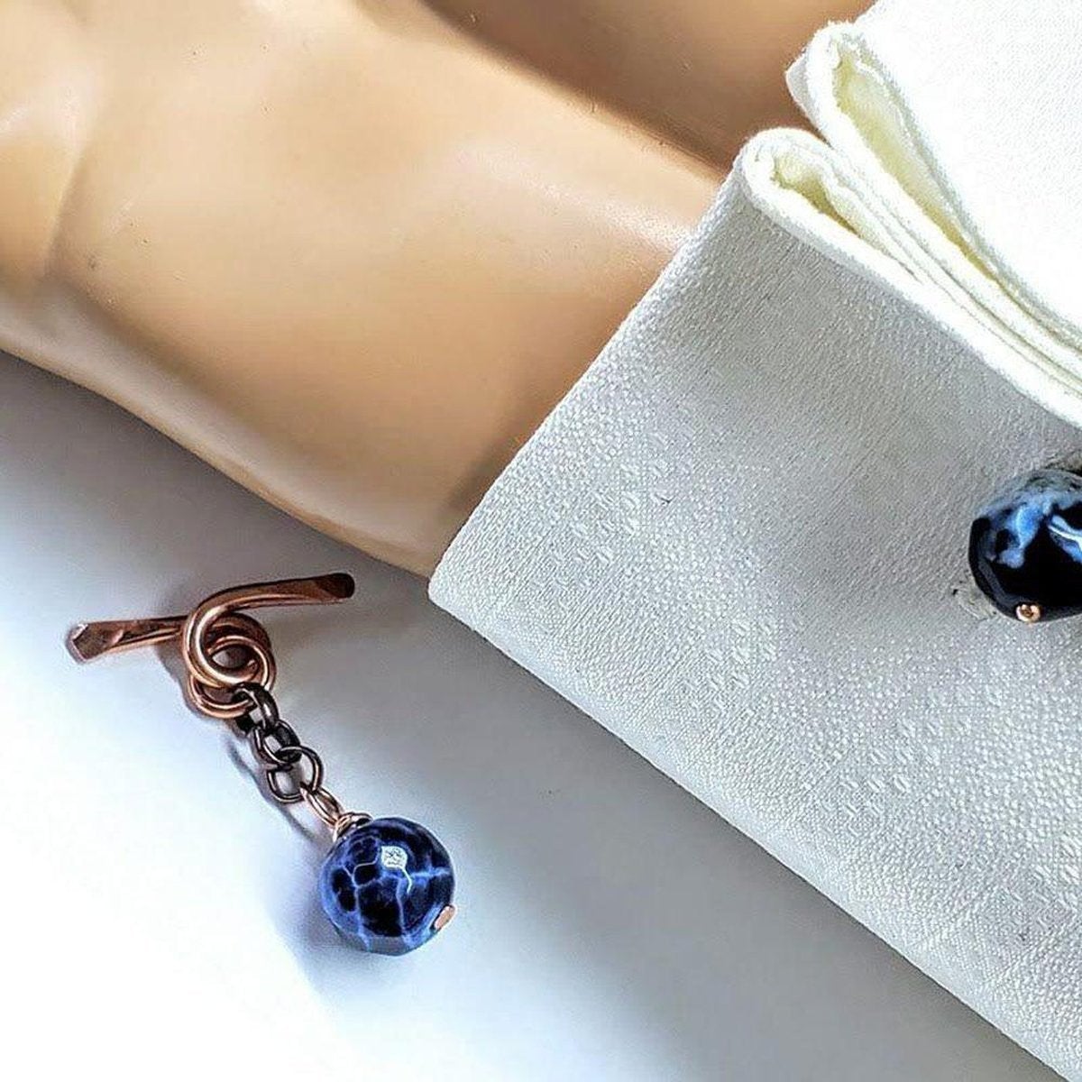 Handcrafted copper cufflinks featuring unique black blue crackle agate beads, symbolizing child abuse awareness with elegant rose gold hammered toggle.