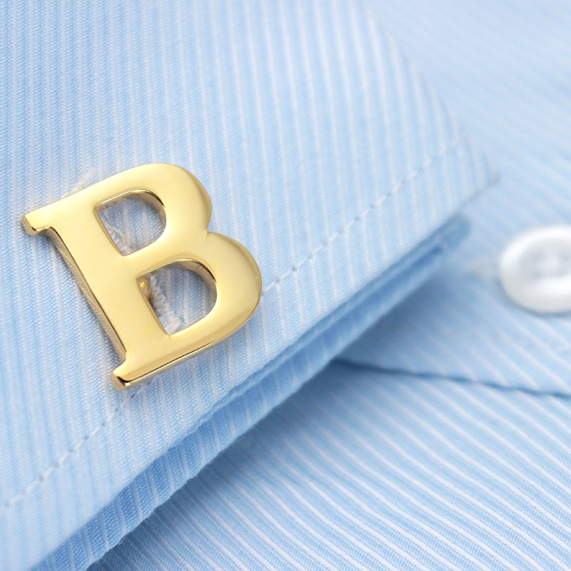 A pair of elegant golden cufflinks featuring capitalized alphabets, beautifully crafted from brass and gold plated, presented in a stylish gift box.