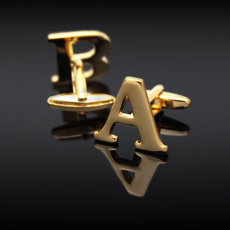 A pair of elegant golden cufflinks featuring capitalized alphabets, beautifully crafted from brass and gold plated, presented in a stylish gift box.