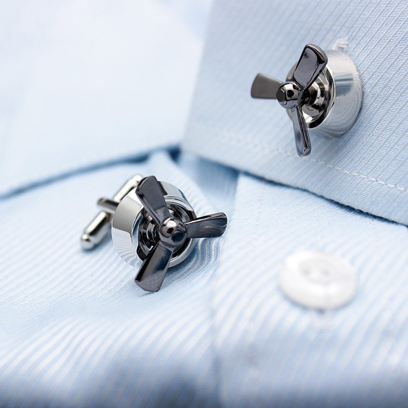 A pair of luxurious propeller cufflinks made from titanium alloy with chrome plating, featuring a unique rotating design, displayed in a hard-sided presentation box.