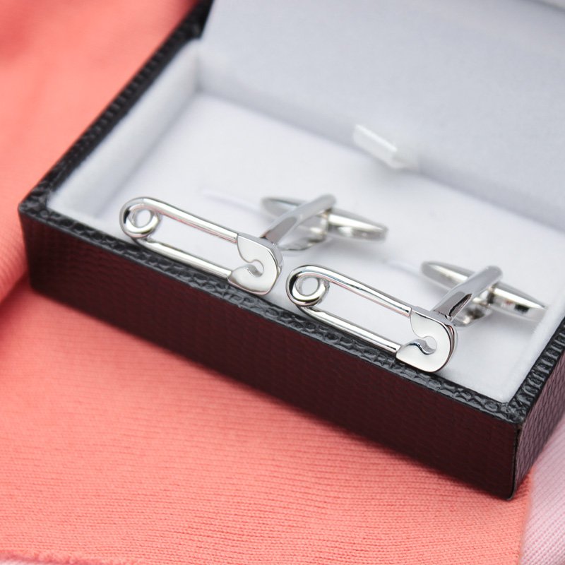 A pair of stylish Safety Pin Cufflinks made from titanium alloy, featuring a unique design with a luxury surface finish, presented in a hard-sided box.