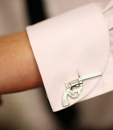 A pair of stylish silver revolver cufflinks made from bronze and rhodium plated, displayed in a hard-sided presentation box.