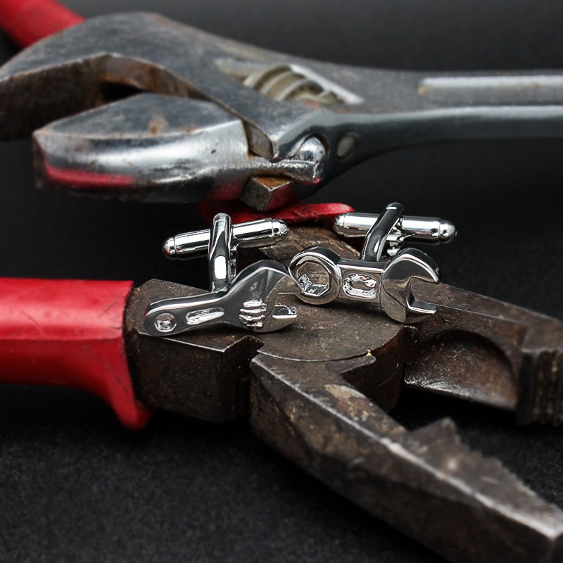 A pair of elegant Spanner Cufflinks made from titanium alloy, featuring a sleek design and perfect plating finish, displayed in a hard-sided presentation box.