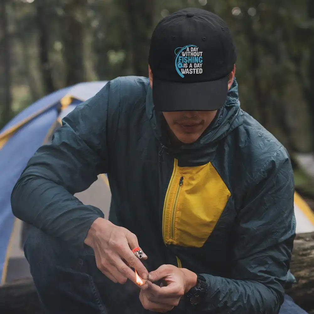 A stylish embroidered baseball hat featuring the phrase 'A Day Without Fishing', made of 100% cotton with a snapback closure.