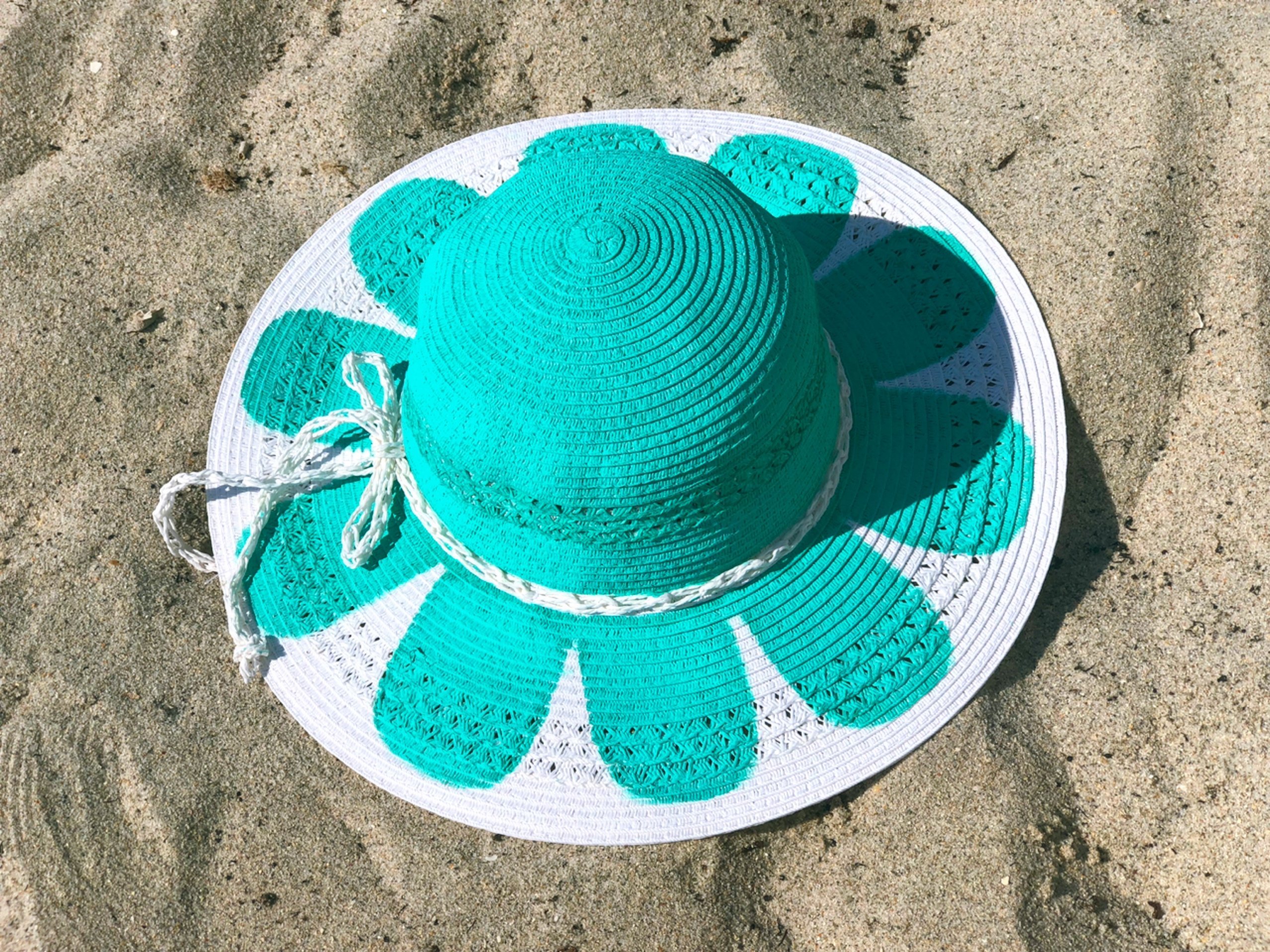 Aqua handpainted sun hat featuring vibrant floral designs, showcasing unique craftsmanship and artistry.