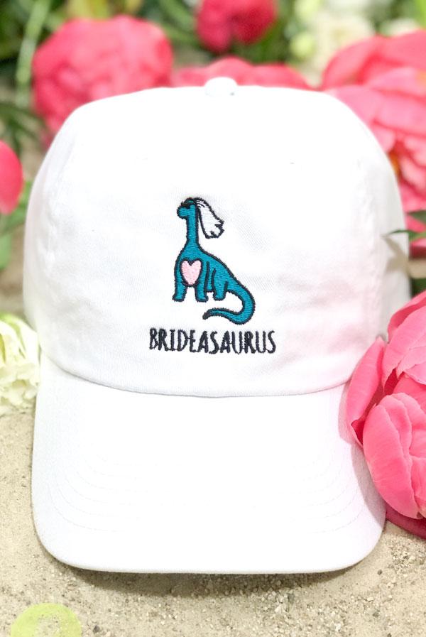 A-Roar-Able Brideasaurus Dad Hats in white and soft pink, featuring fun embroidered designs for brides.