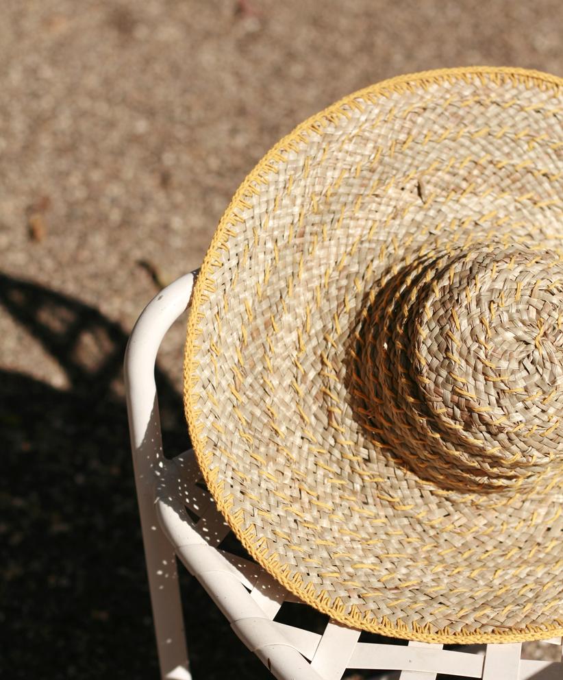 Balinese Pecatu Wide Round Straw Hat in Butter Yellow, handmade from seagrass with a flexible structure and dyed cotton strings.