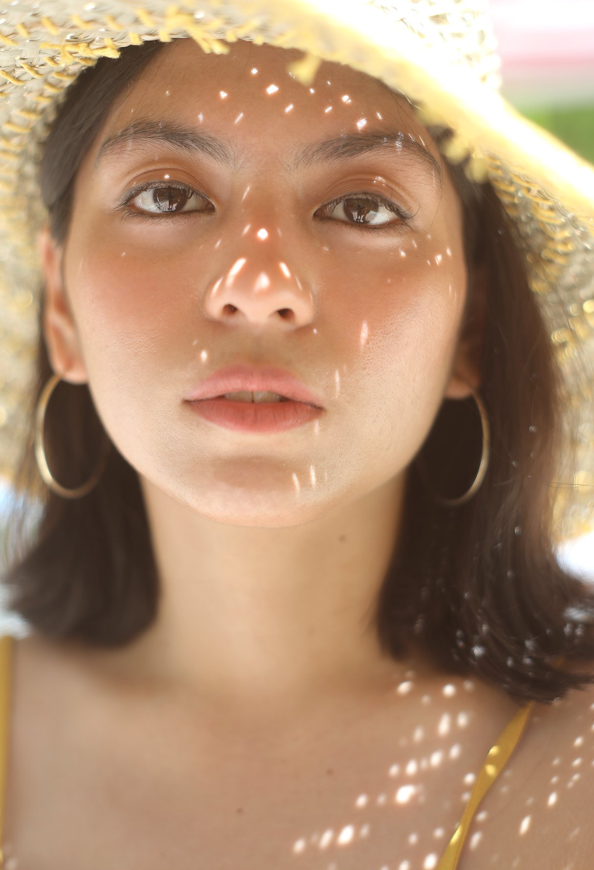 Balinese Pecatu Wide Round Straw Hat in Butter Yellow, handmade from seagrass with a flexible structure and dyed cotton strings.