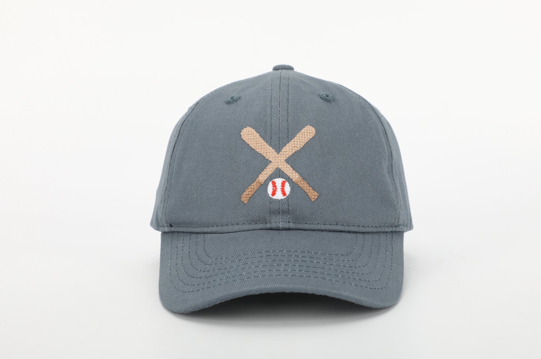 A stylish baseball hat for kids featuring a cognac leather adjustable strap and needlepoint embroidery designs.