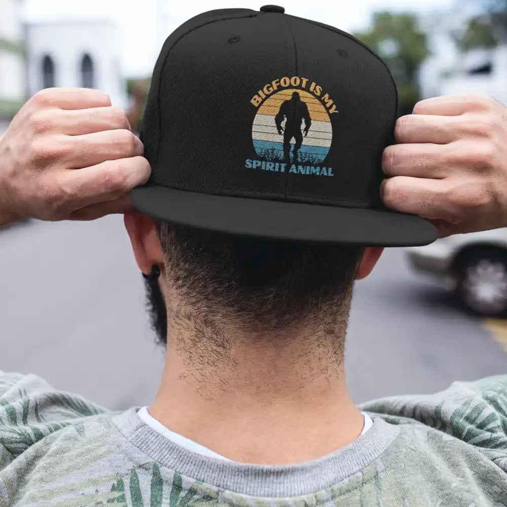 Bigfoot Is My Spirit Animal Embroidered Flat Bill Cap featuring a structured design and green under visor.