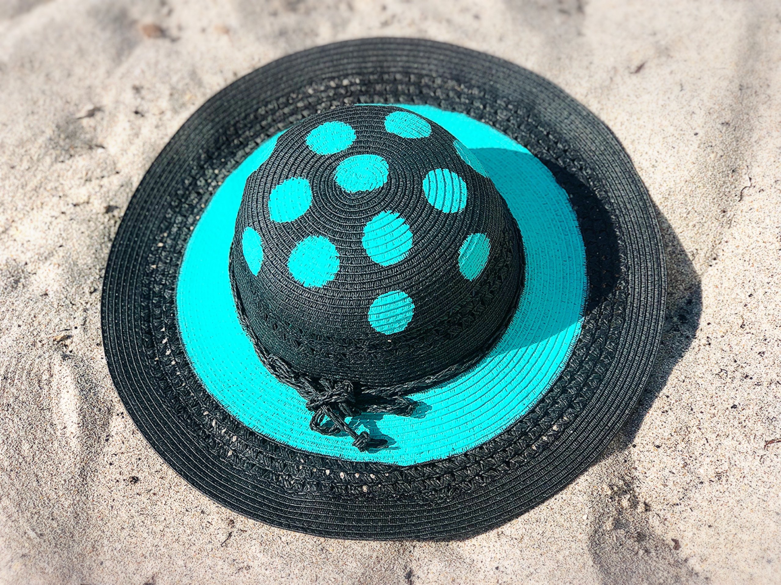 A stylish Black Aqua sun hat featuring a unique polka dot design, handmade and handpainted for a one-of-a-kind look.