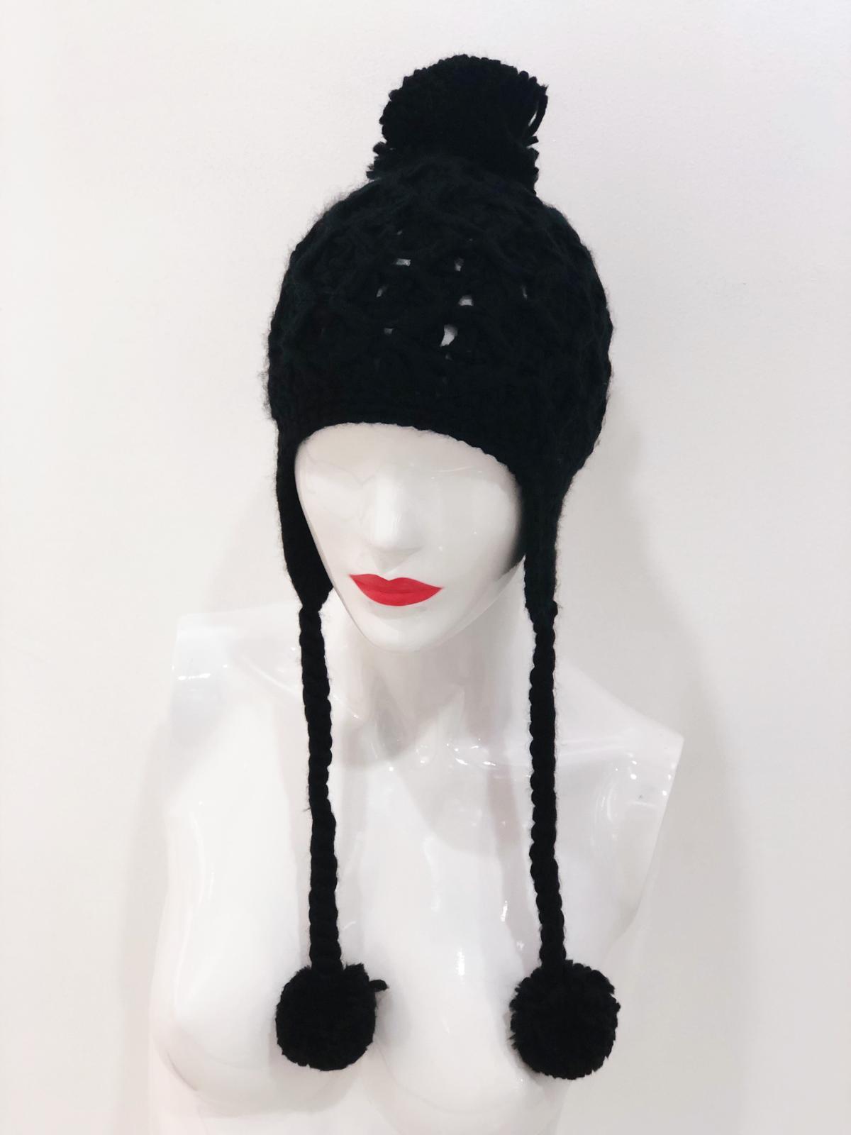 A stylish black beanie with a pom pom on top, perfect for winter wear.