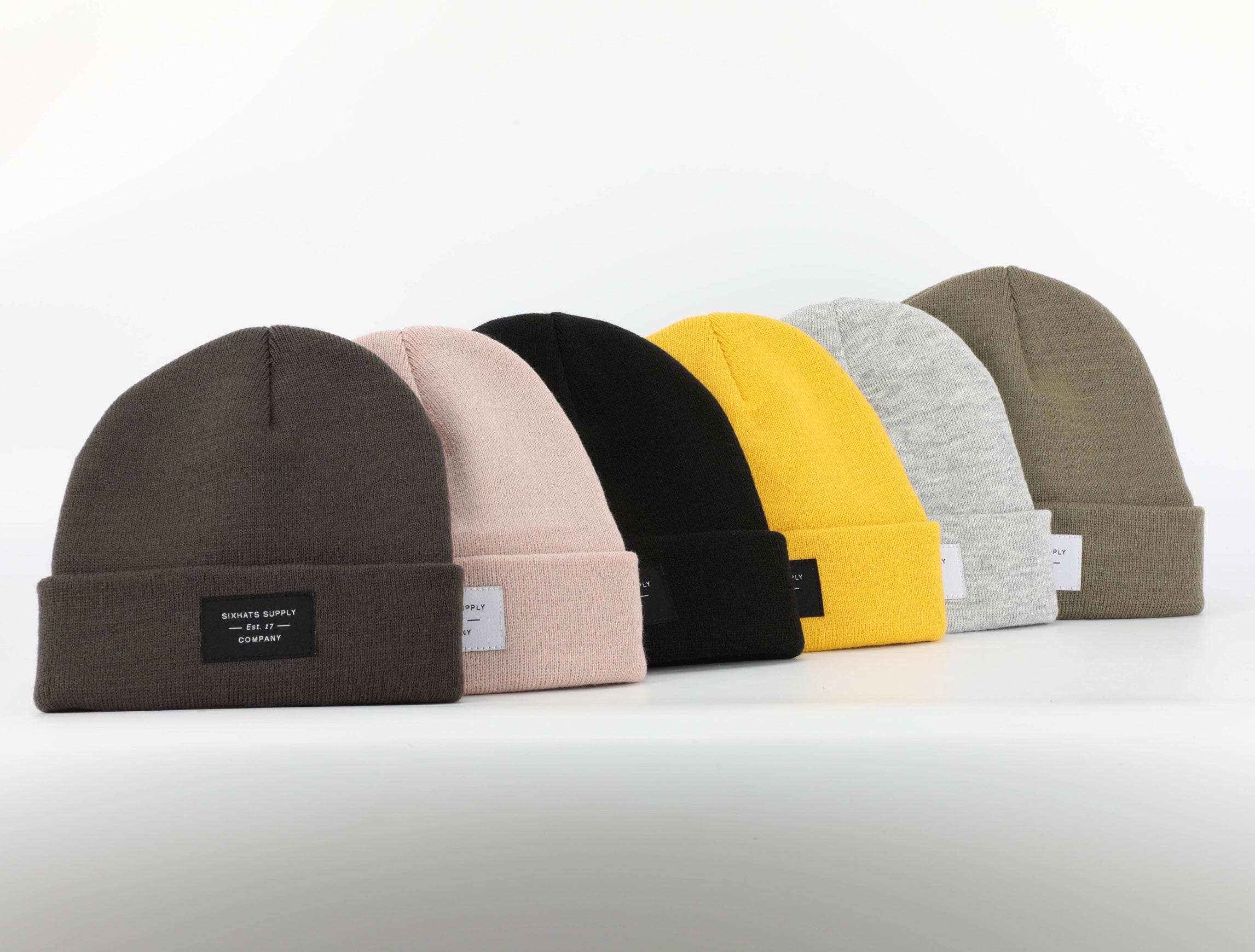 A soft black folding beanie with a woven label, showcasing its stylish design and versatility for various outfits.