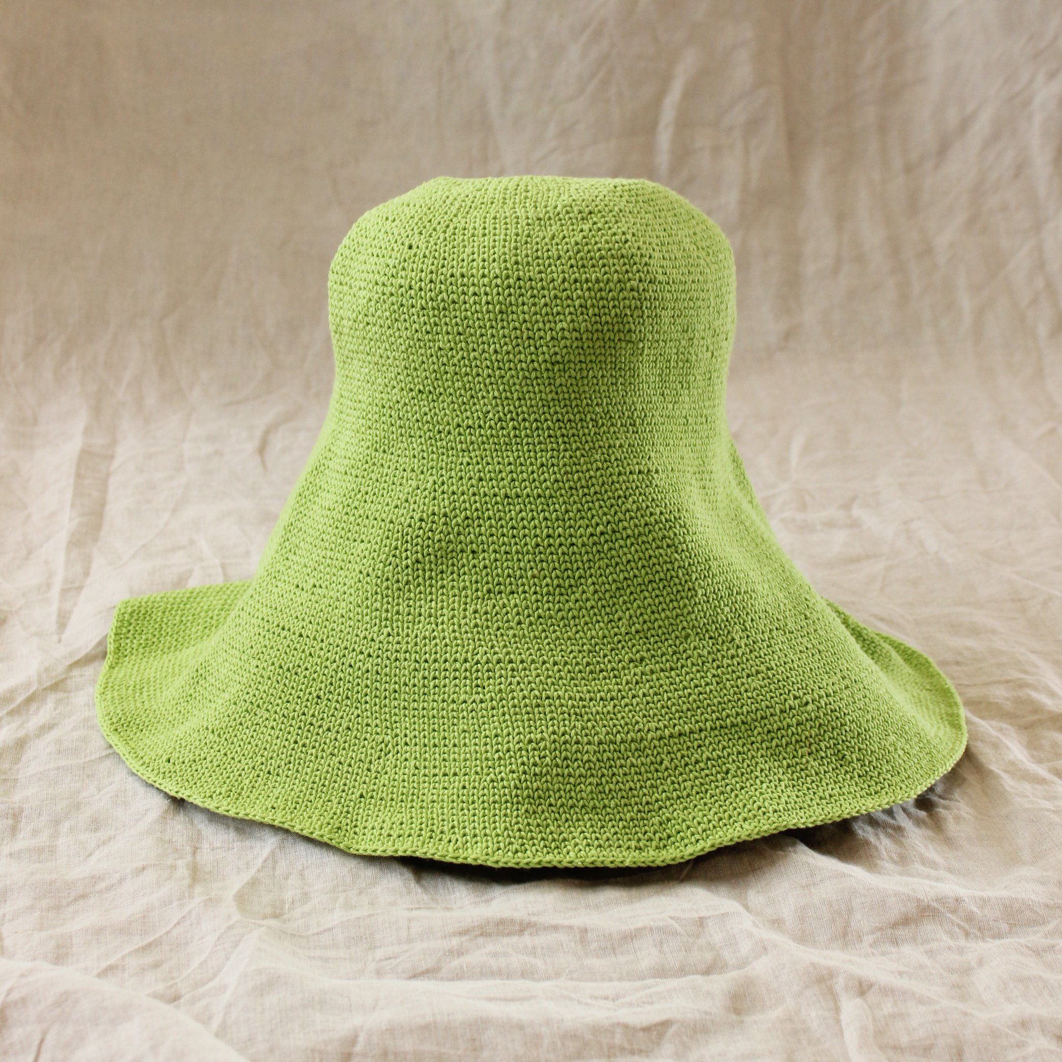 BLOOM Crochet Sun Hat in vibrant lime green, featuring a soft, shapeable design inspired by Calla Lily flowers, perfect for summer outings.