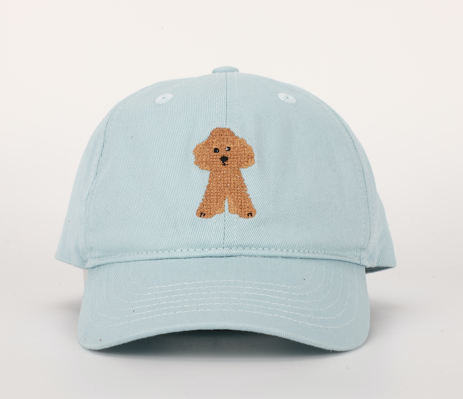 A stylish Blue Golden Doodle Hat for children, featuring a cognac leather adjustable strap and unique needlepoint embroidery designs.