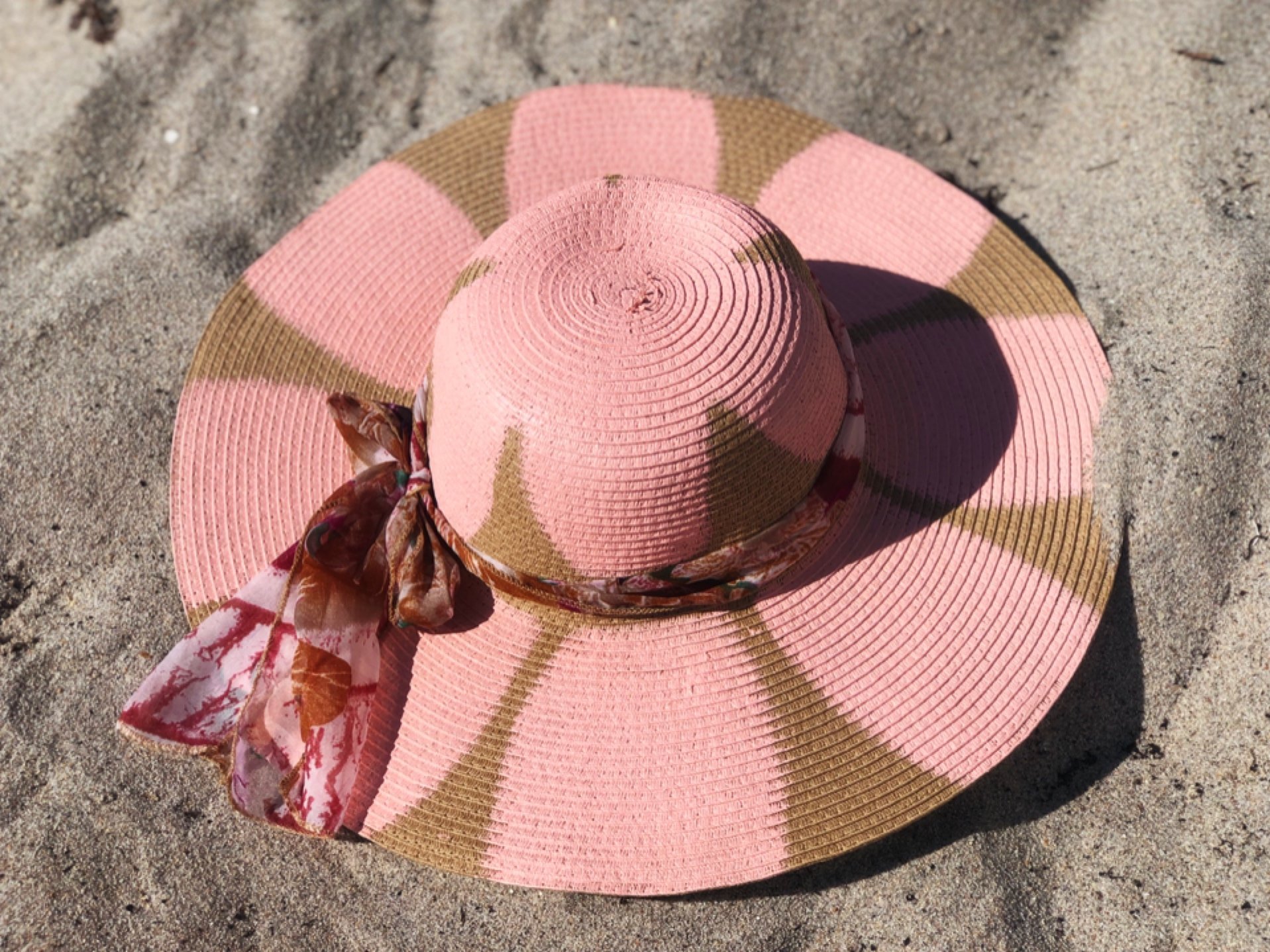 A beautifully handpainted blush sun hat featuring vibrant floral designs, perfect for sunny days.