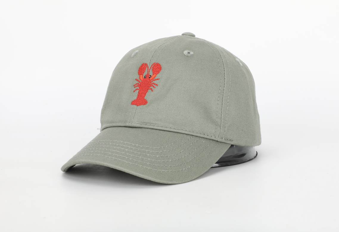 A stylish Claw Hat for children featuring a cognac leather adjustable strap and needlepoint embroidery designs.