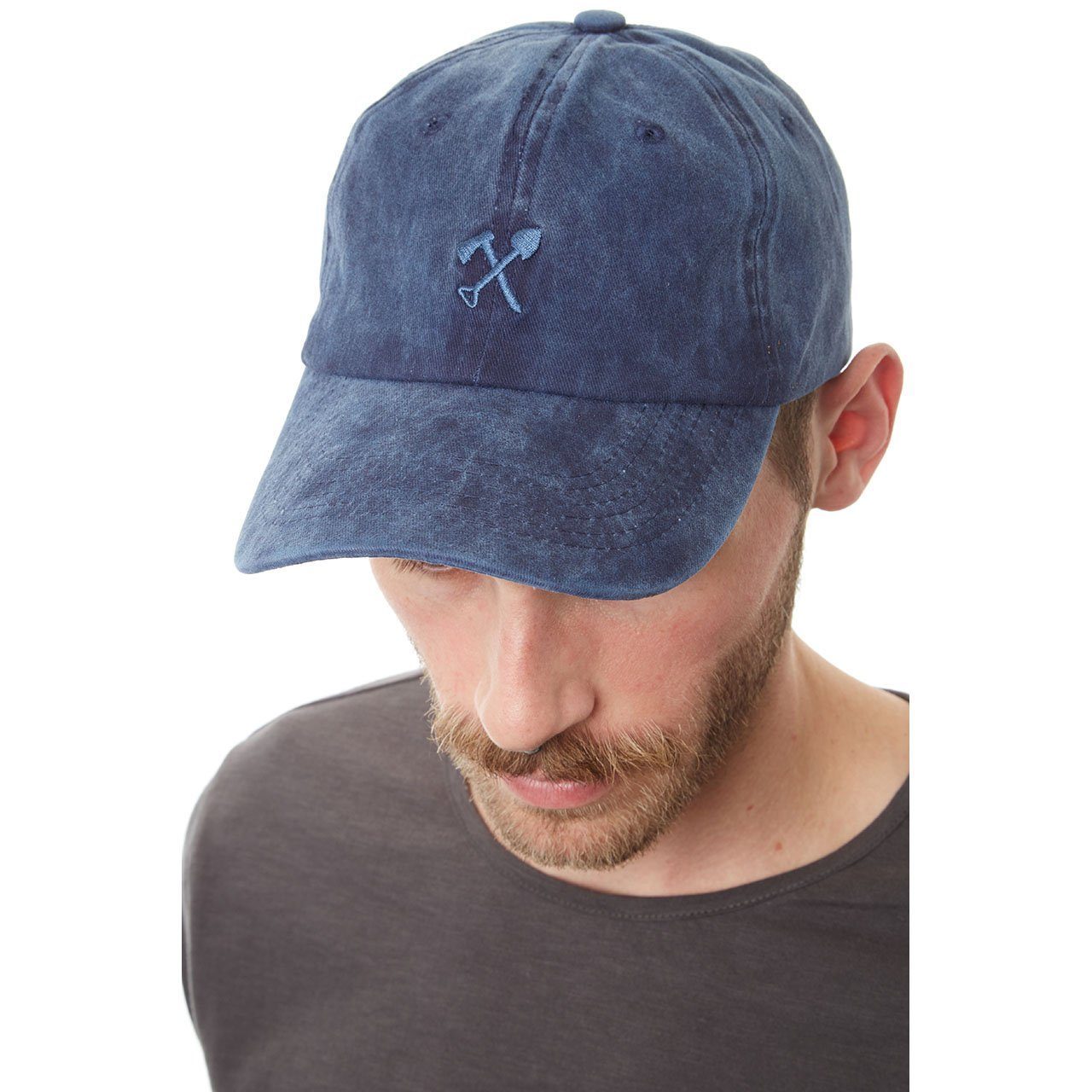 Cody Dad Hat featuring a curved brim and embroidered shovel and ax logo, showcasing a unique snow washed finish.