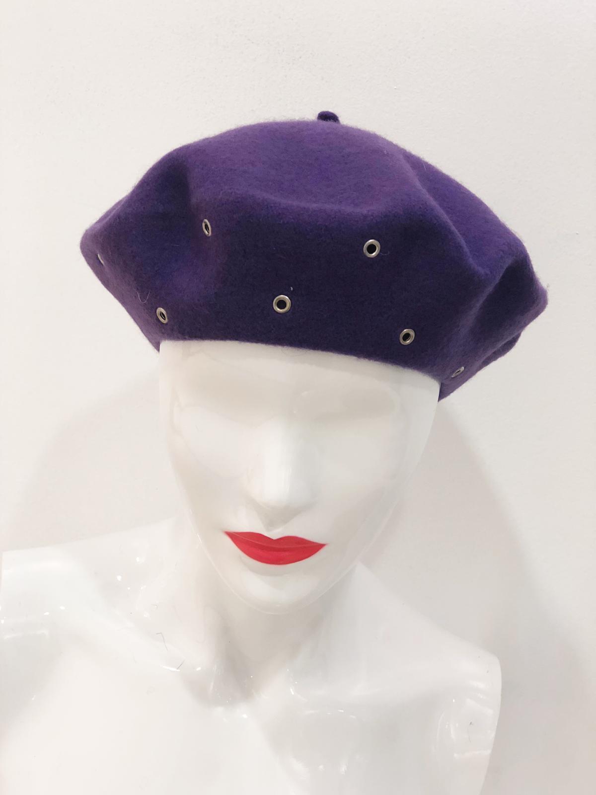 A stylish 'Delaney' Purple Beret displayed on a white background, showcasing its elegant design and rich color.