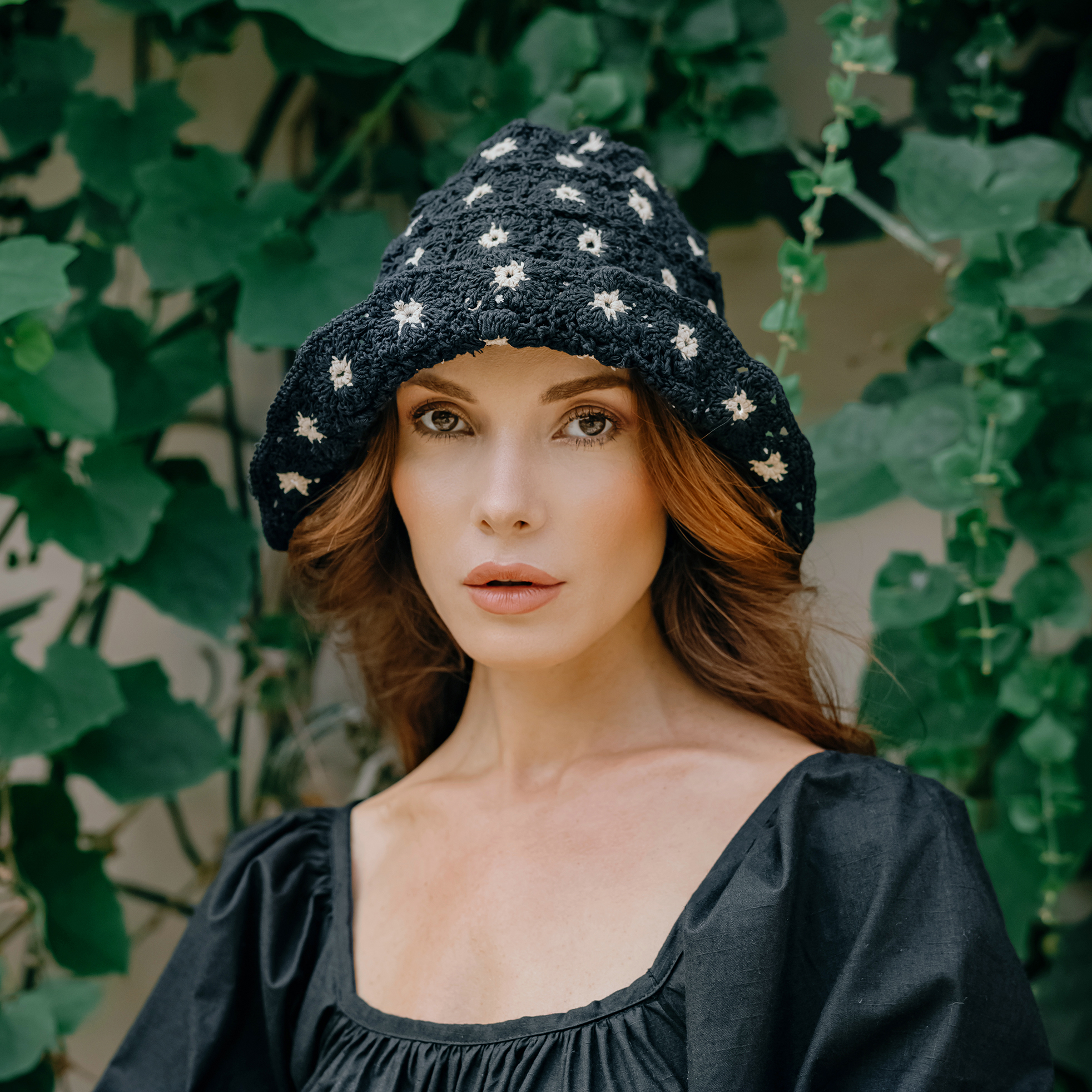 FLORA Crochet Hat in Black featuring a beautiful flower pattern, handcrafted from 100% cotton yarn, perfect for sunny outdoor occasions.