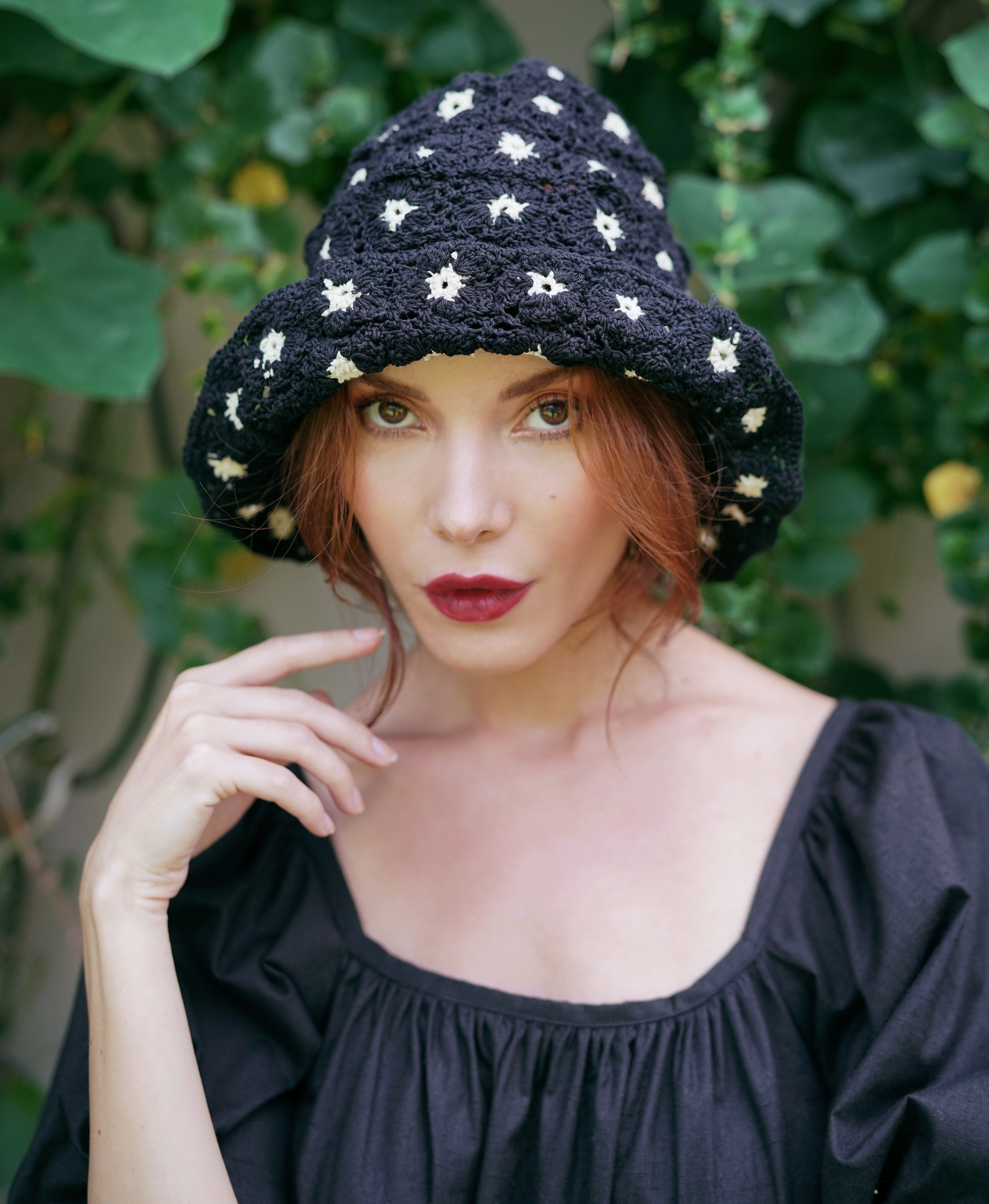 FLORA Crochet Hat in Black featuring a beautiful flower pattern, handcrafted from 100% cotton yarn, perfect for sunny outdoor occasions.