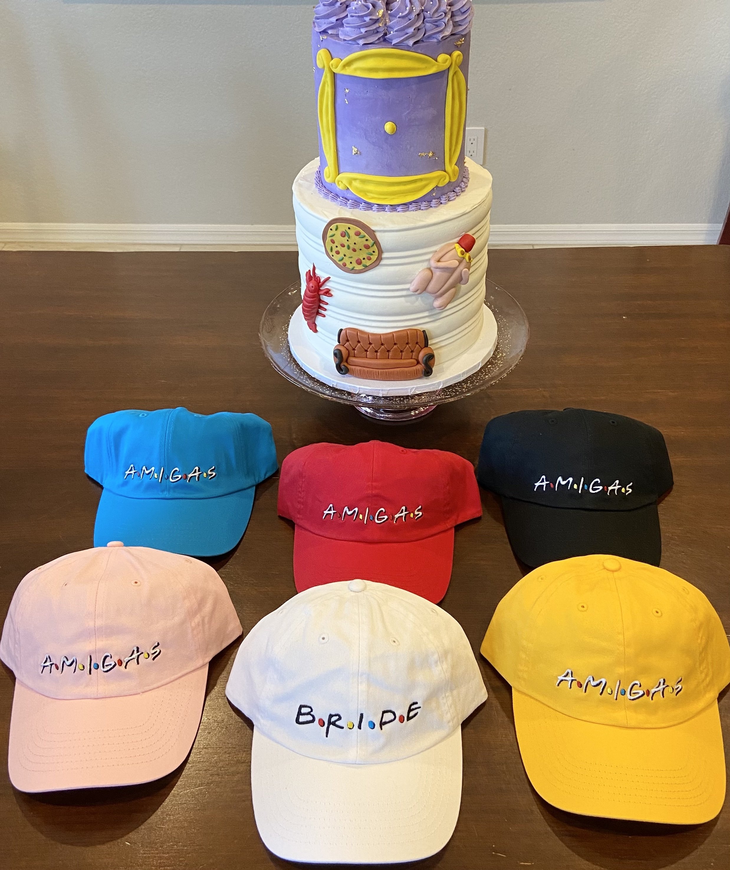 A stylish white hat labeled 'Bride' alongside colorful hats labeled 'Amigas', perfect for bachelorette parties.