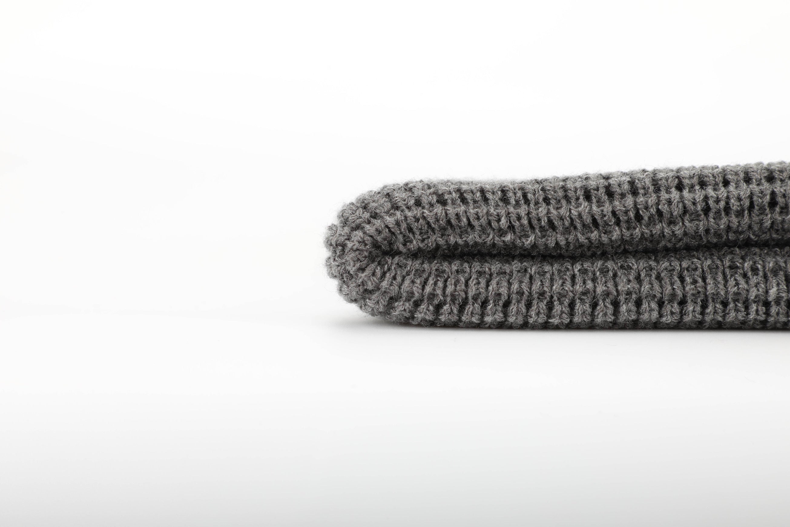 A stylish grey waffle knit beanie designed for warmth and comfort, featuring a woven Black Tree & Tent Explorer label.