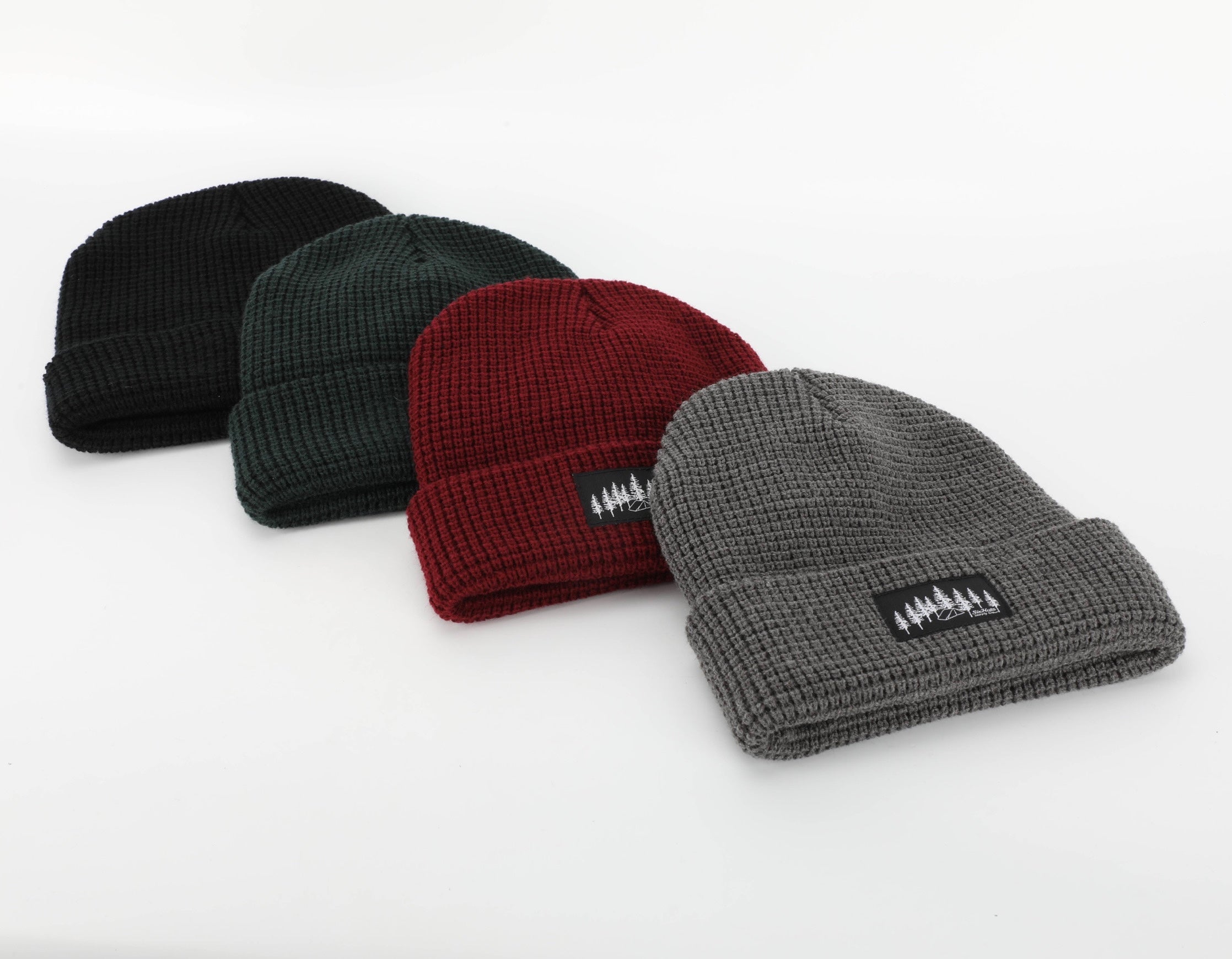 A stylish grey waffle knit beanie designed for warmth and comfort, featuring a woven Black Tree & Tent Explorer label.