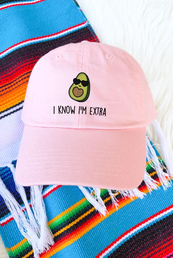 A collection of colorful fiesta avocado hats with fun phrases for weddings and celebrations, showcasing a white and soft pink design.