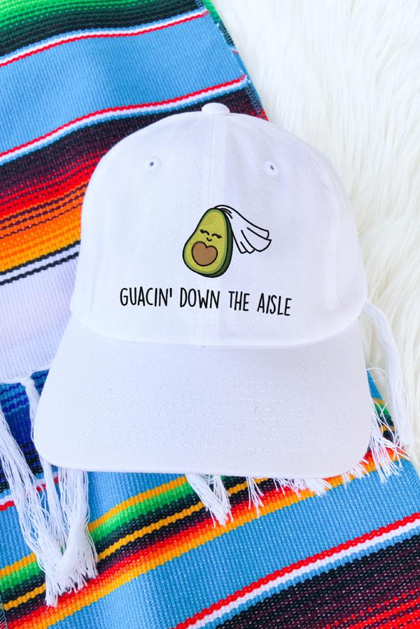 A collection of colorful fiesta avocado hats with fun phrases for weddings and celebrations, showcasing a white and soft pink design.