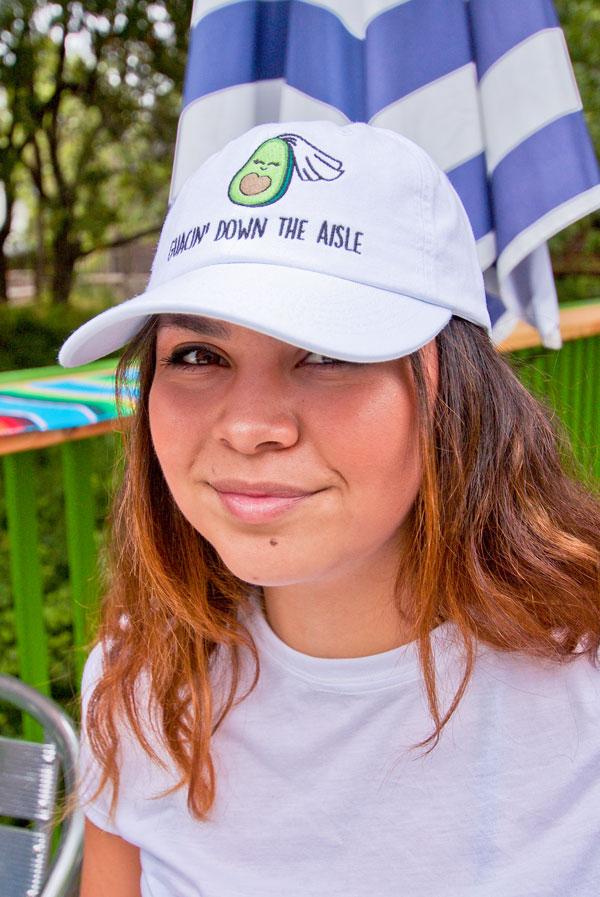 A collection of colorful fiesta avocado hats with fun phrases for weddings and celebrations, showcasing a white and soft pink design.