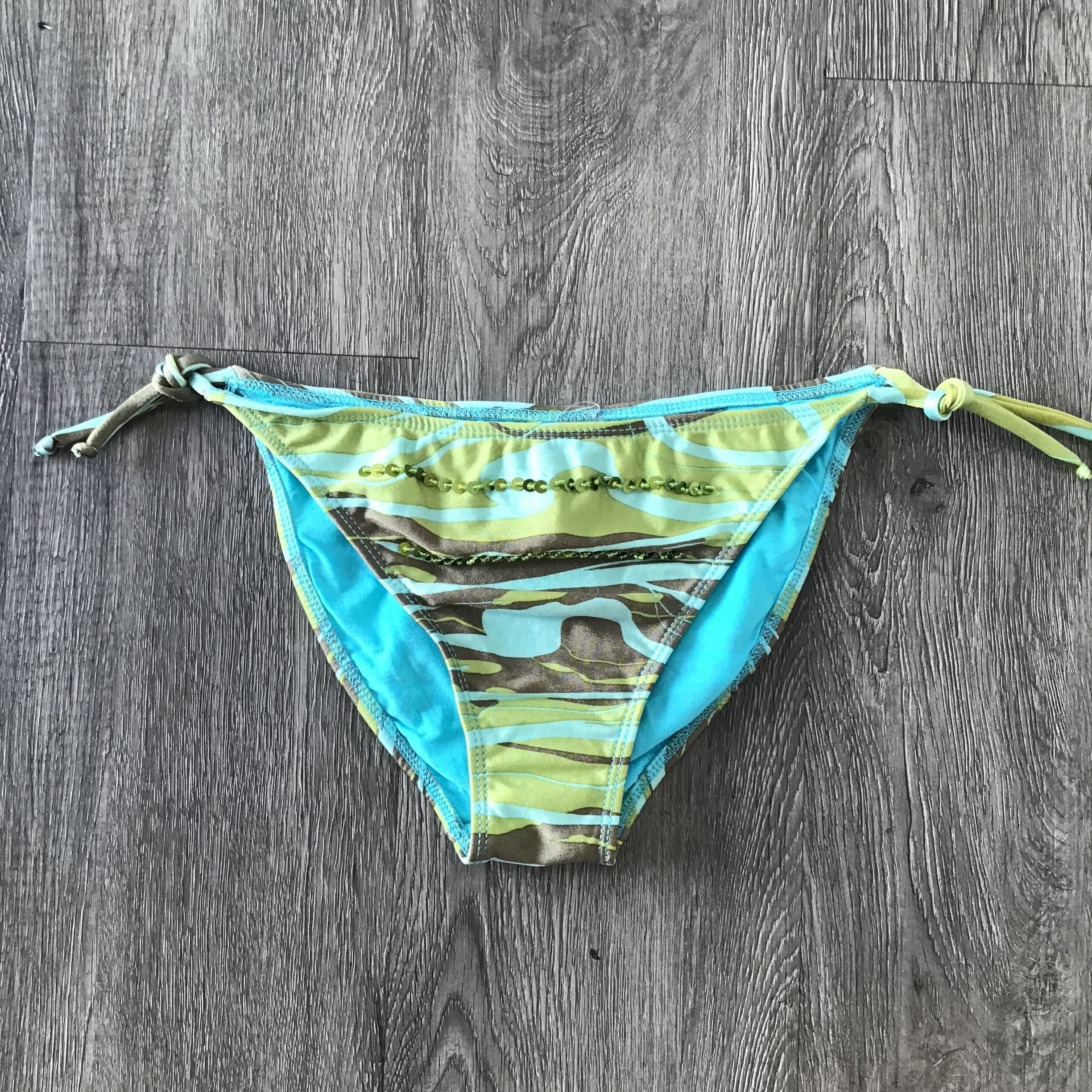 Kali Green Bikini Bottom displayed on a flat surface, showcasing its vibrant color and stylish design.