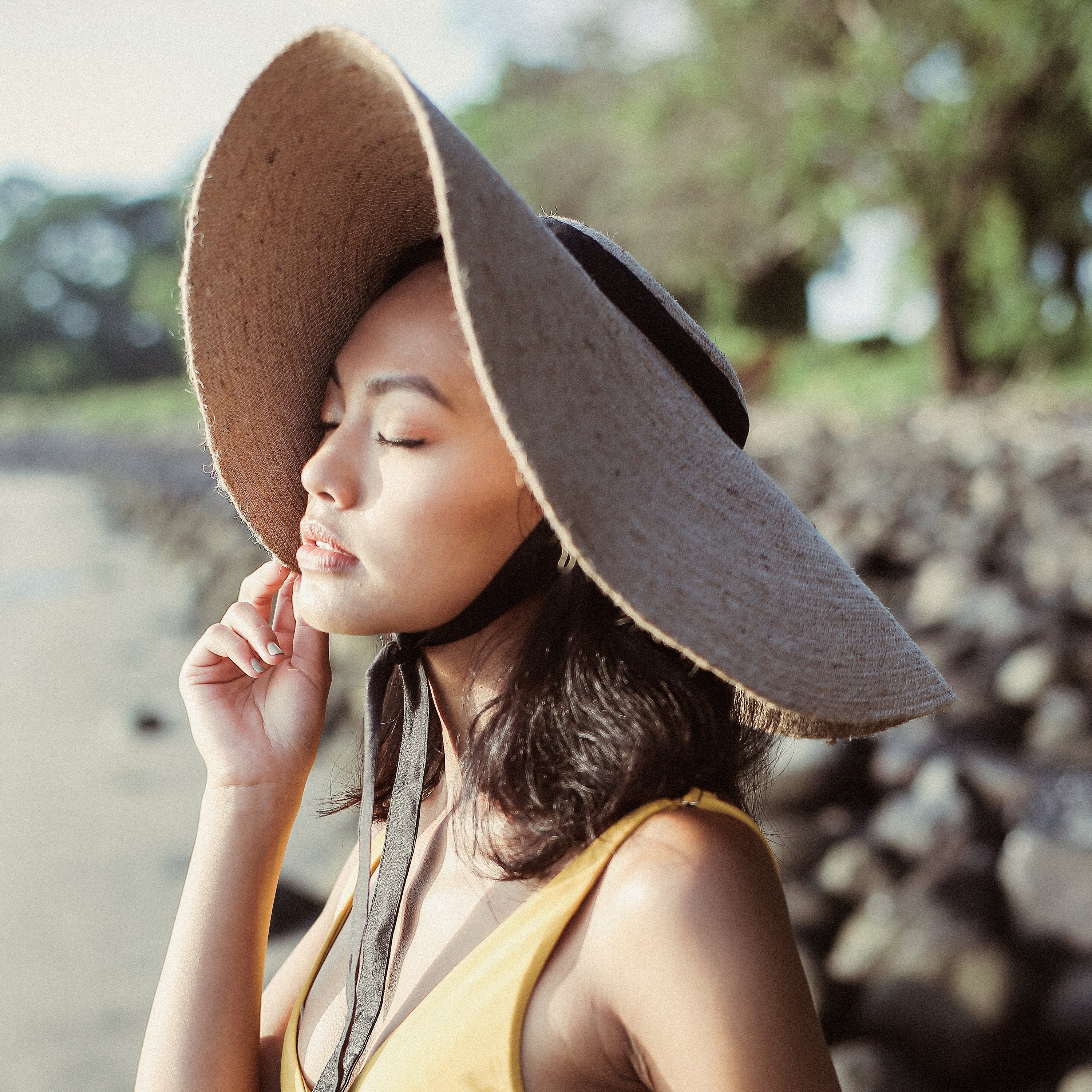 LOLA Wide Brim Jute Straw Hat featuring a black strap, elegantly crafted from natural jute, perfect for summer outings.