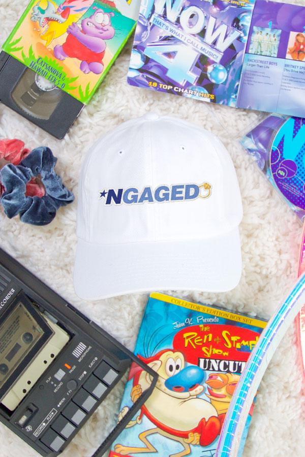 White cap with "NGAGED" text surrounded by nostalgic items.