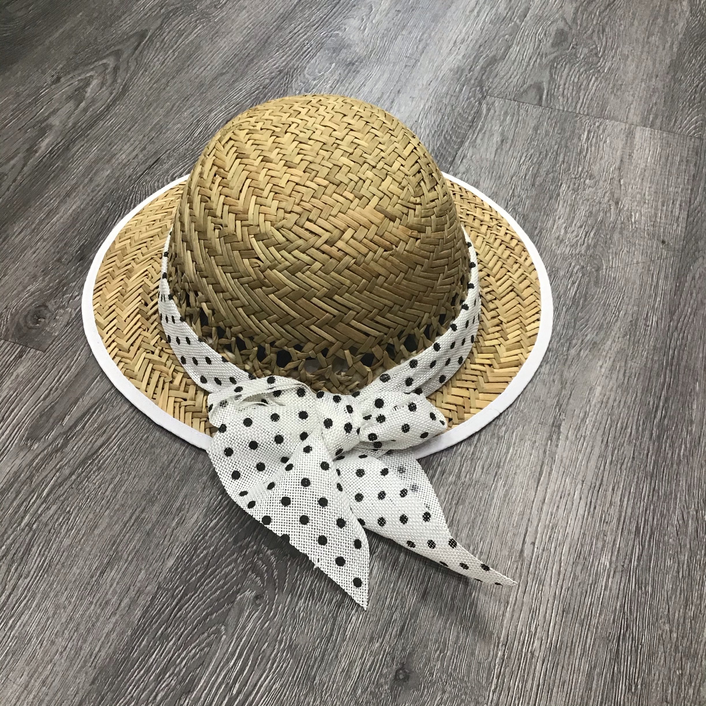 A stylish Polka Dot Bow Straw Visor featuring a playful polka dot pattern and a chic bow accent, perfect for sunny days.