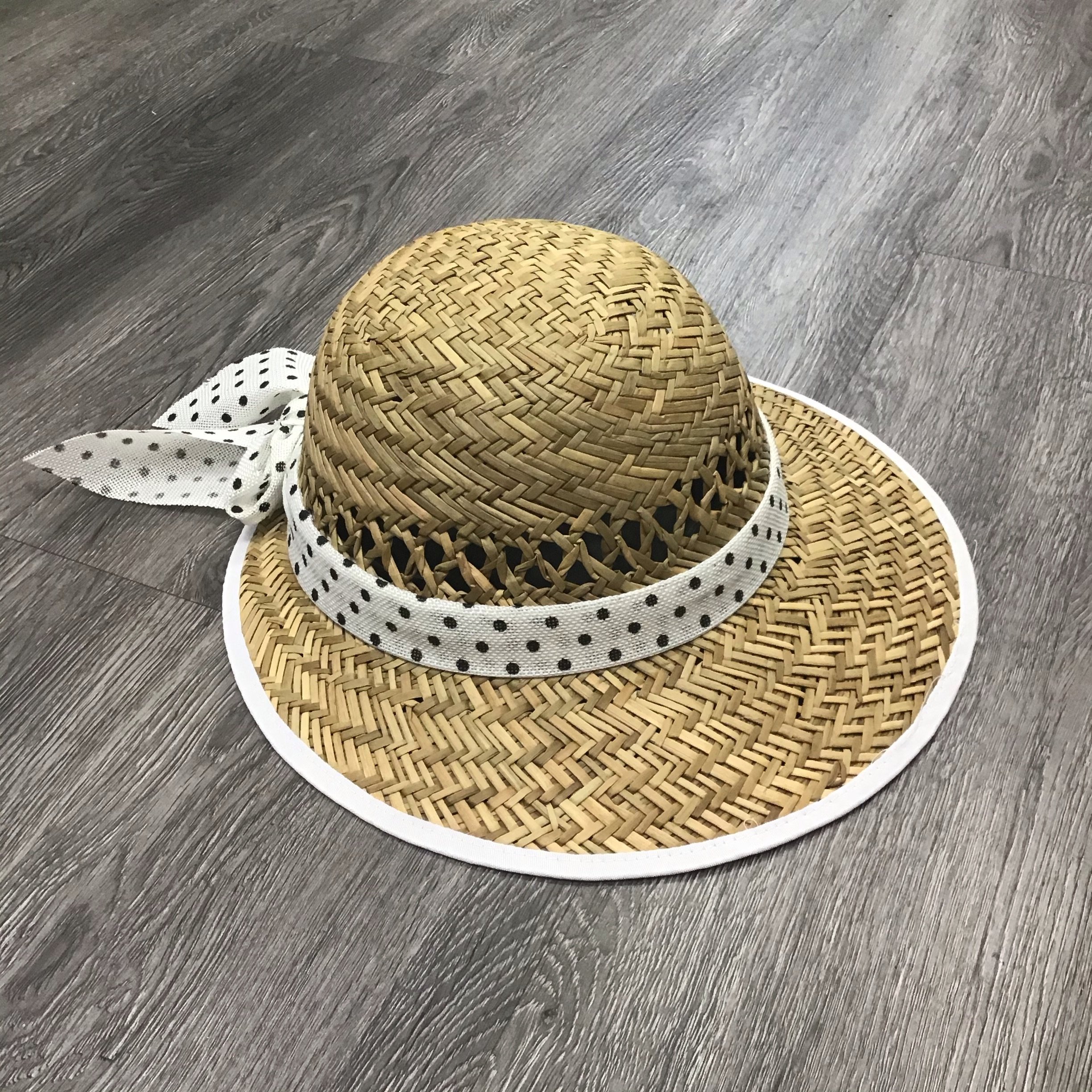 A stylish Polka Dot Bow Straw Visor featuring a playful polka dot pattern and a chic bow accent, perfect for sunny days.