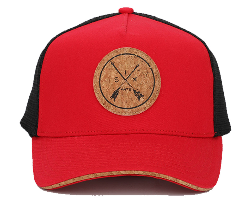 Red and black snapback hat with cork brim and mesh back, featuring a round recycled cork patch.