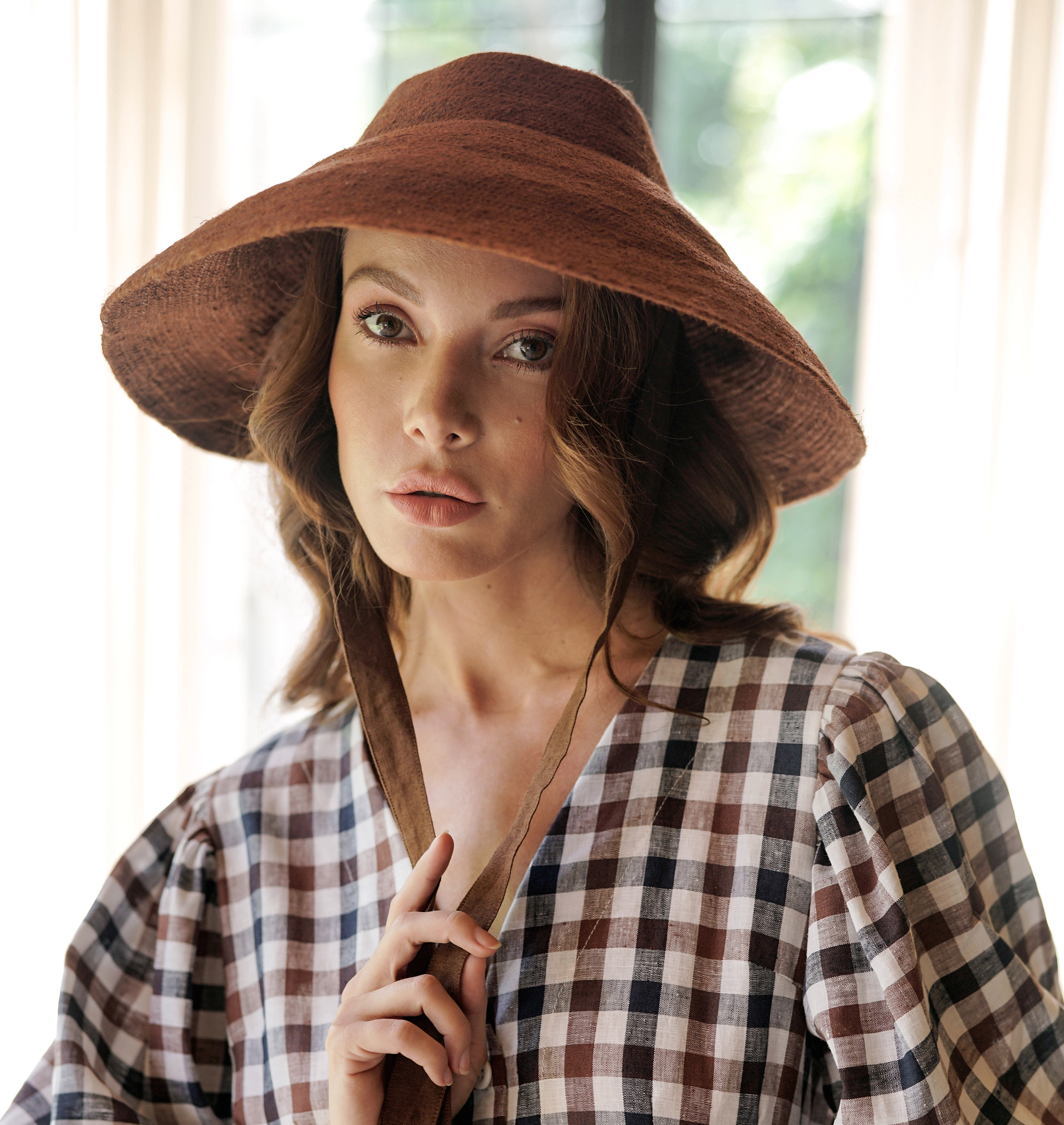 REIGN Jute Hat in Burnt Sienna, showcasing its downturned brim and natural jute straw texture.