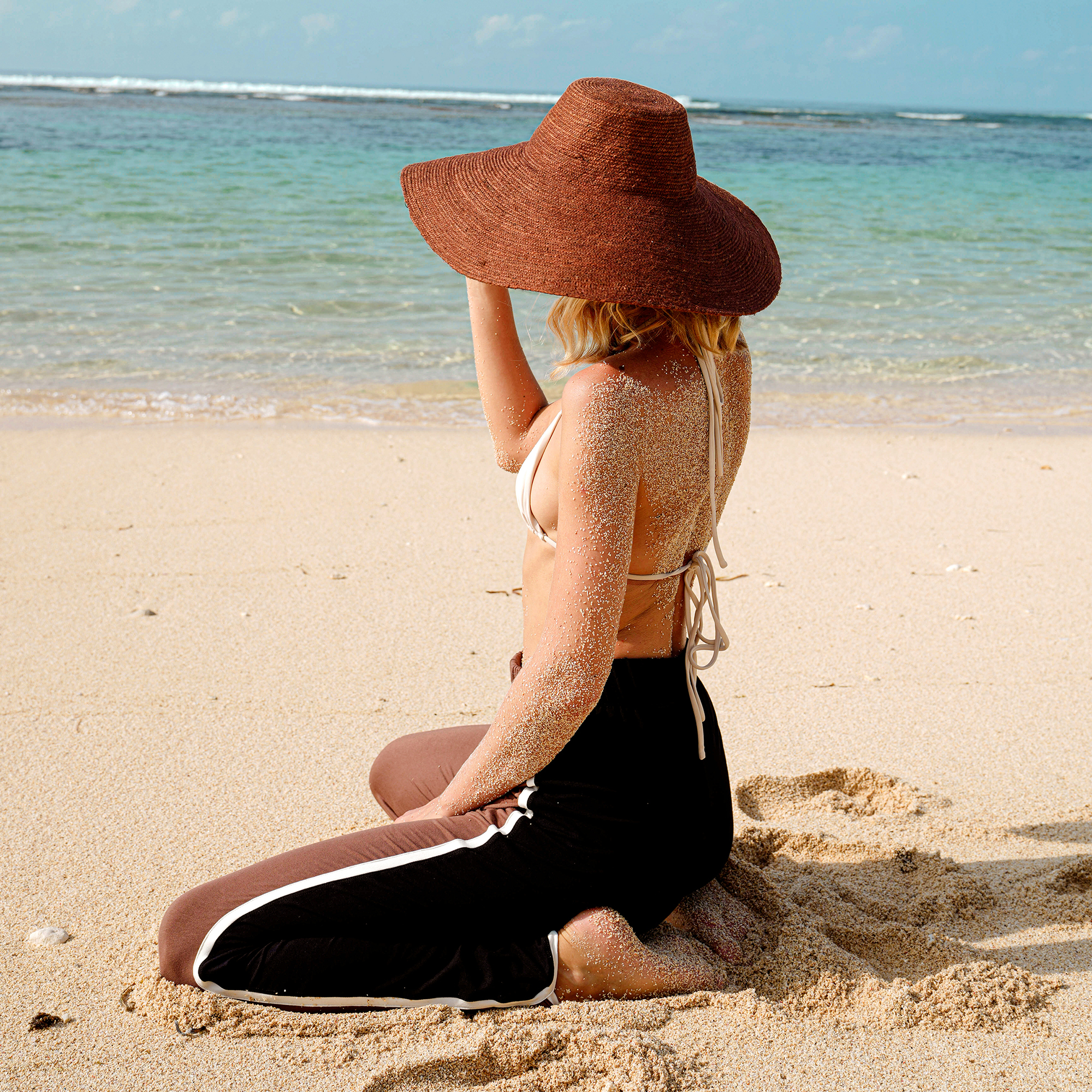 RIRI Jute Handwoven Straw Hat in Burnt Sienna with a wide brim, showcasing its natural jute texture and stylish design.