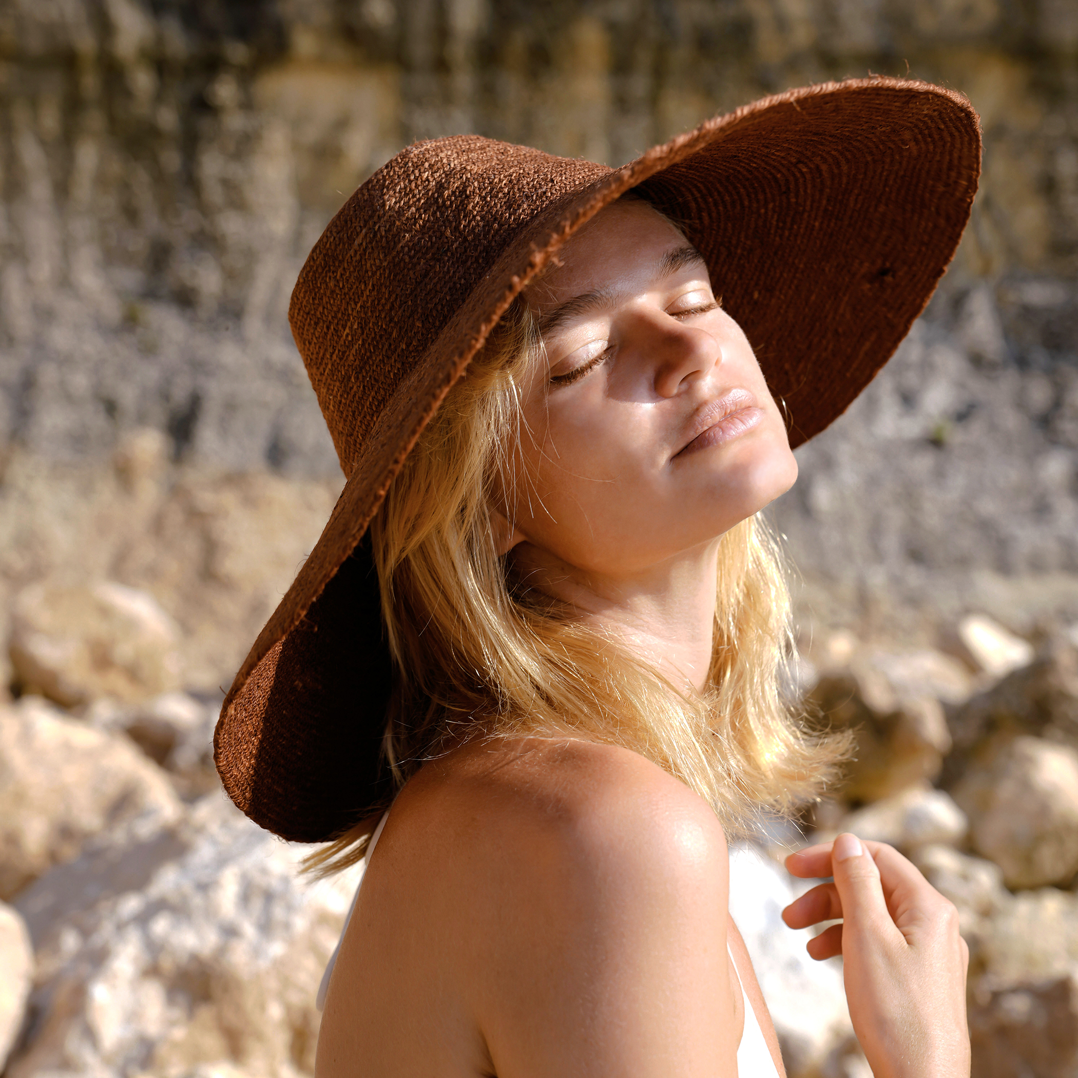 RIRI Jute Handwoven Straw Hat in Burnt Sienna with a wide brim, showcasing its natural jute texture and stylish design.