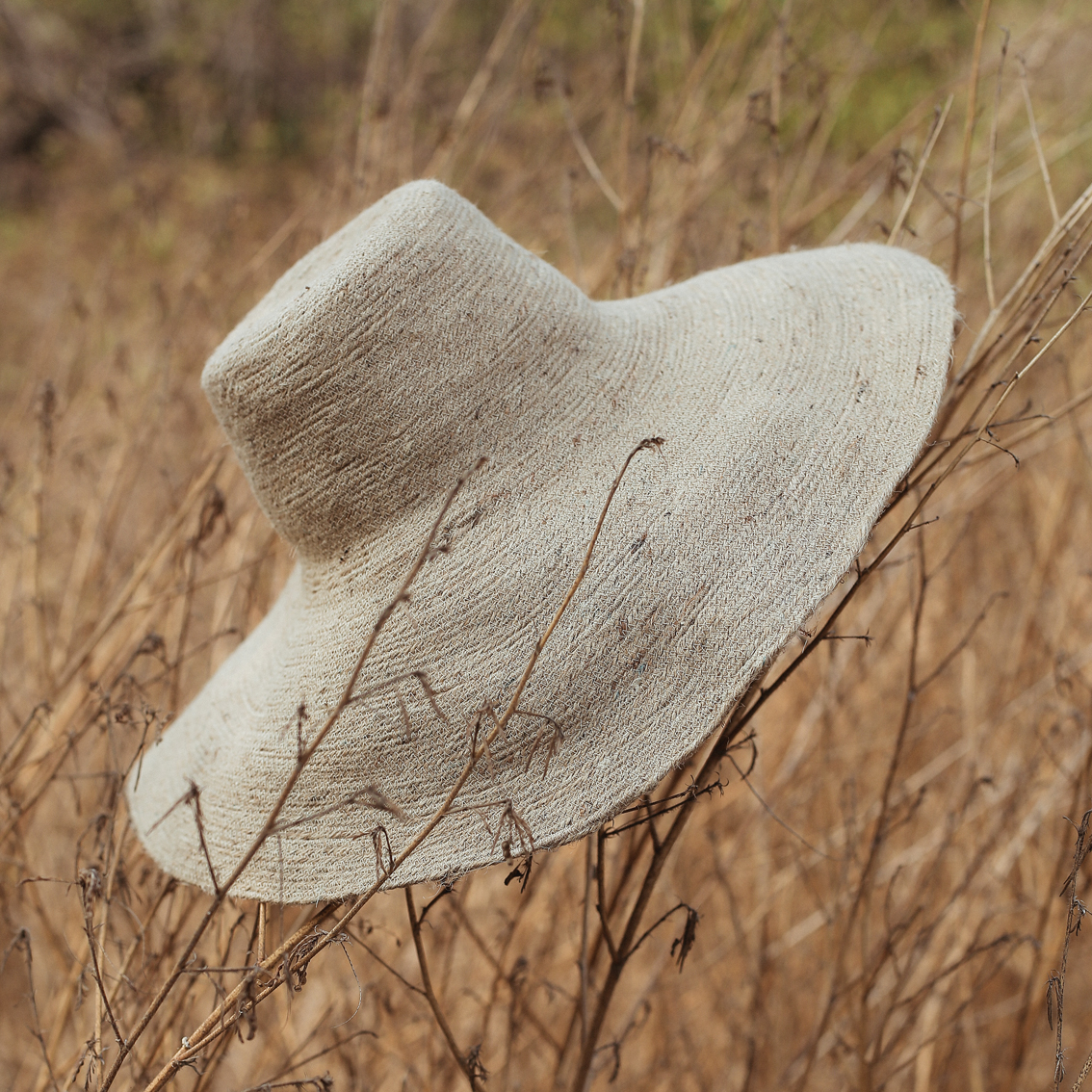 RIRI Jute Handwoven Straw Hat in Natural Beige with a wide brim, showcasing its eco-friendly jute material and comfortable cotton inner strap.