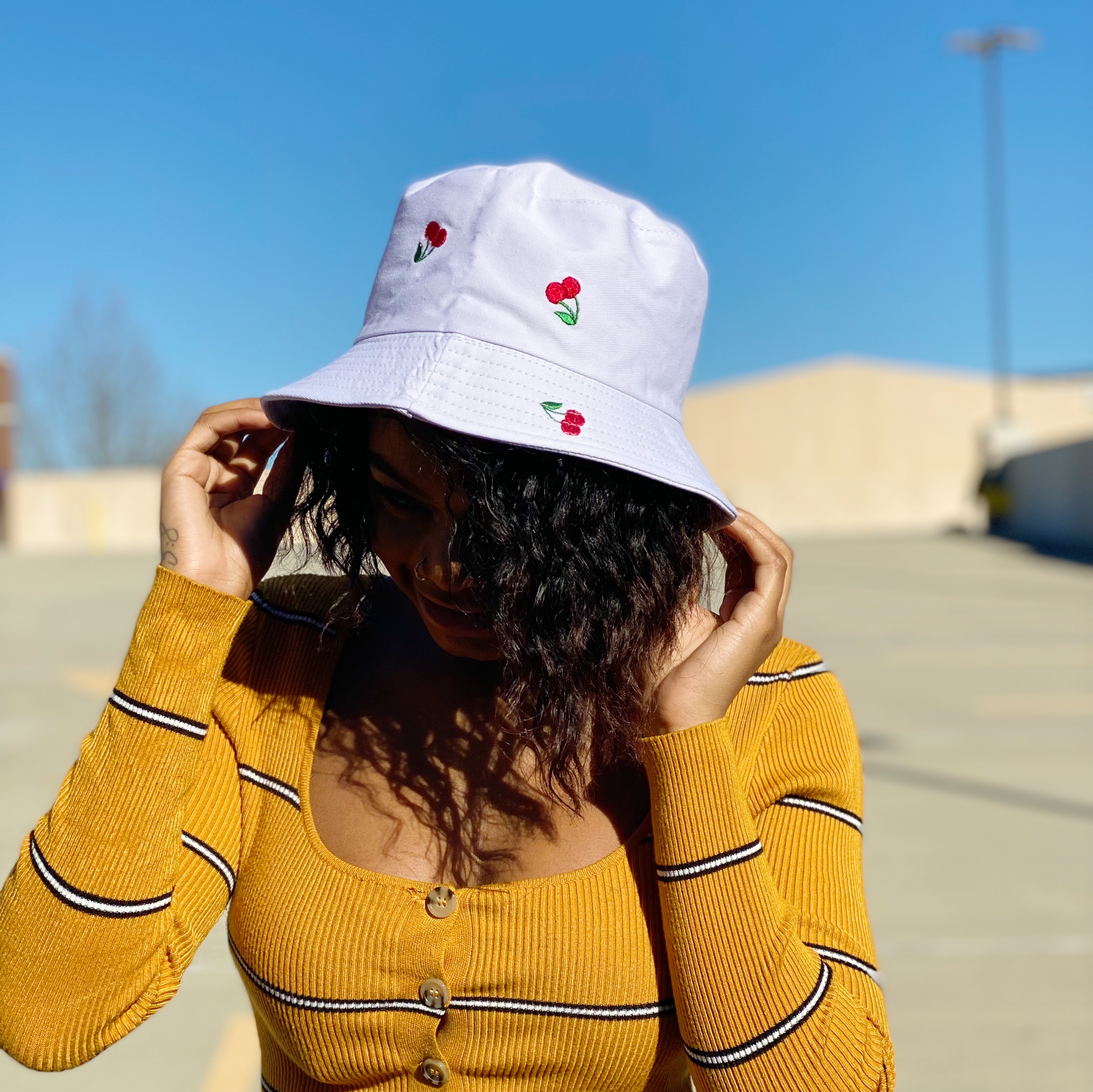 A colorful bucket hat with embroidered fruit patterns, made of high-quality cotton, perfect for sunny days.