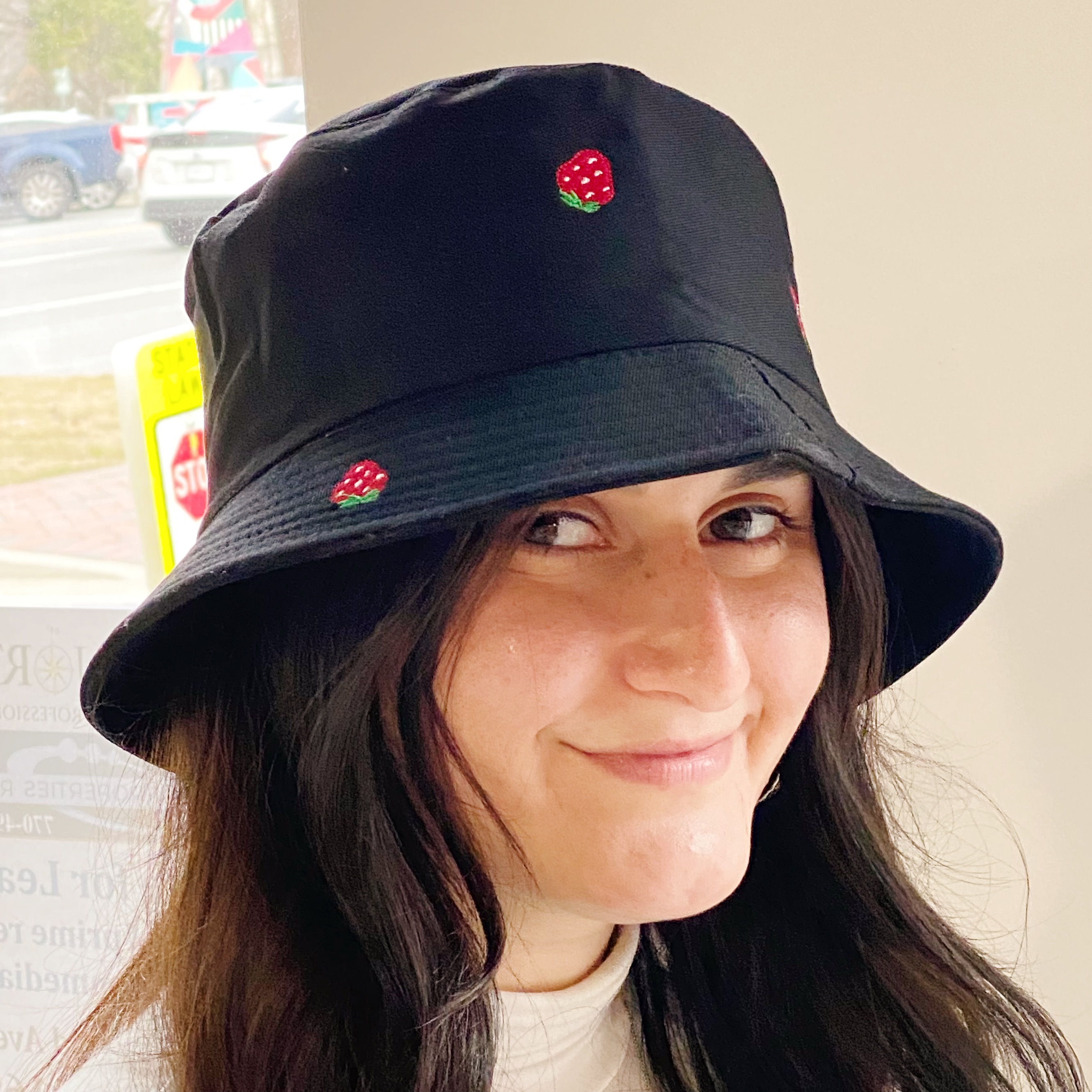 A colorful bucket hat with embroidered fruit patterns, made of high-quality cotton, perfect for sunny days.