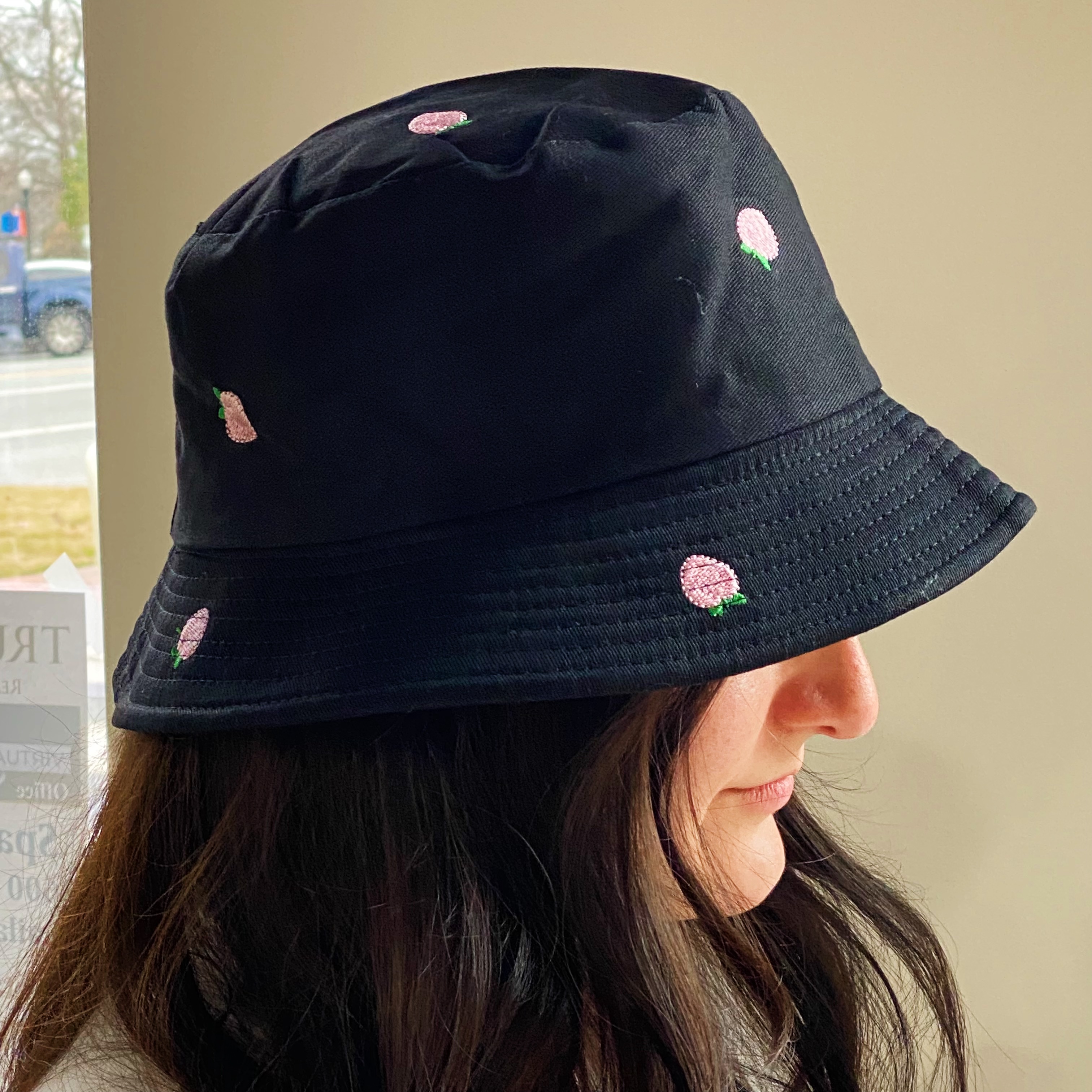 A colorful bucket hat with embroidered fruit patterns, made of high-quality cotton, perfect for sunny days.