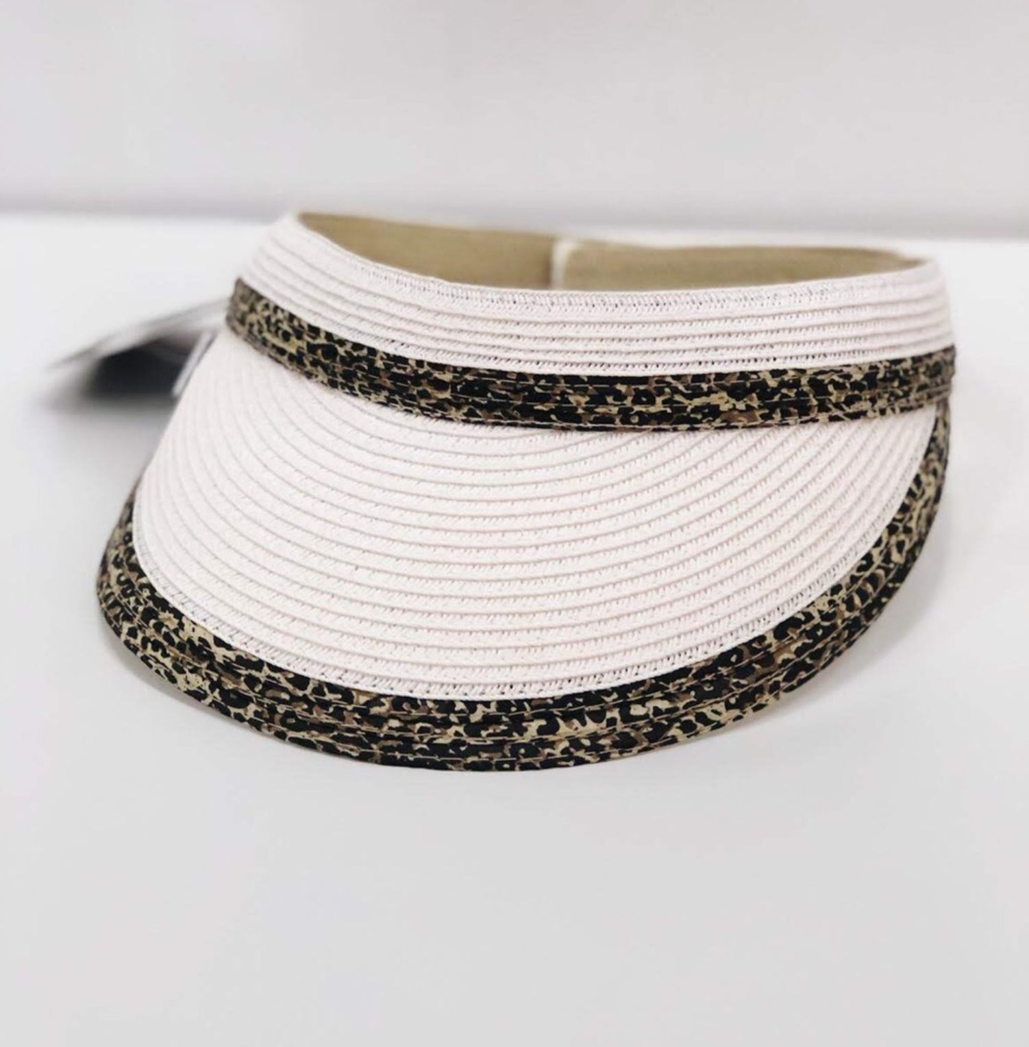 A stylish white animal print visor hat made from toyo braid material with a 3.5-inch brim and adjustable velcro closure.