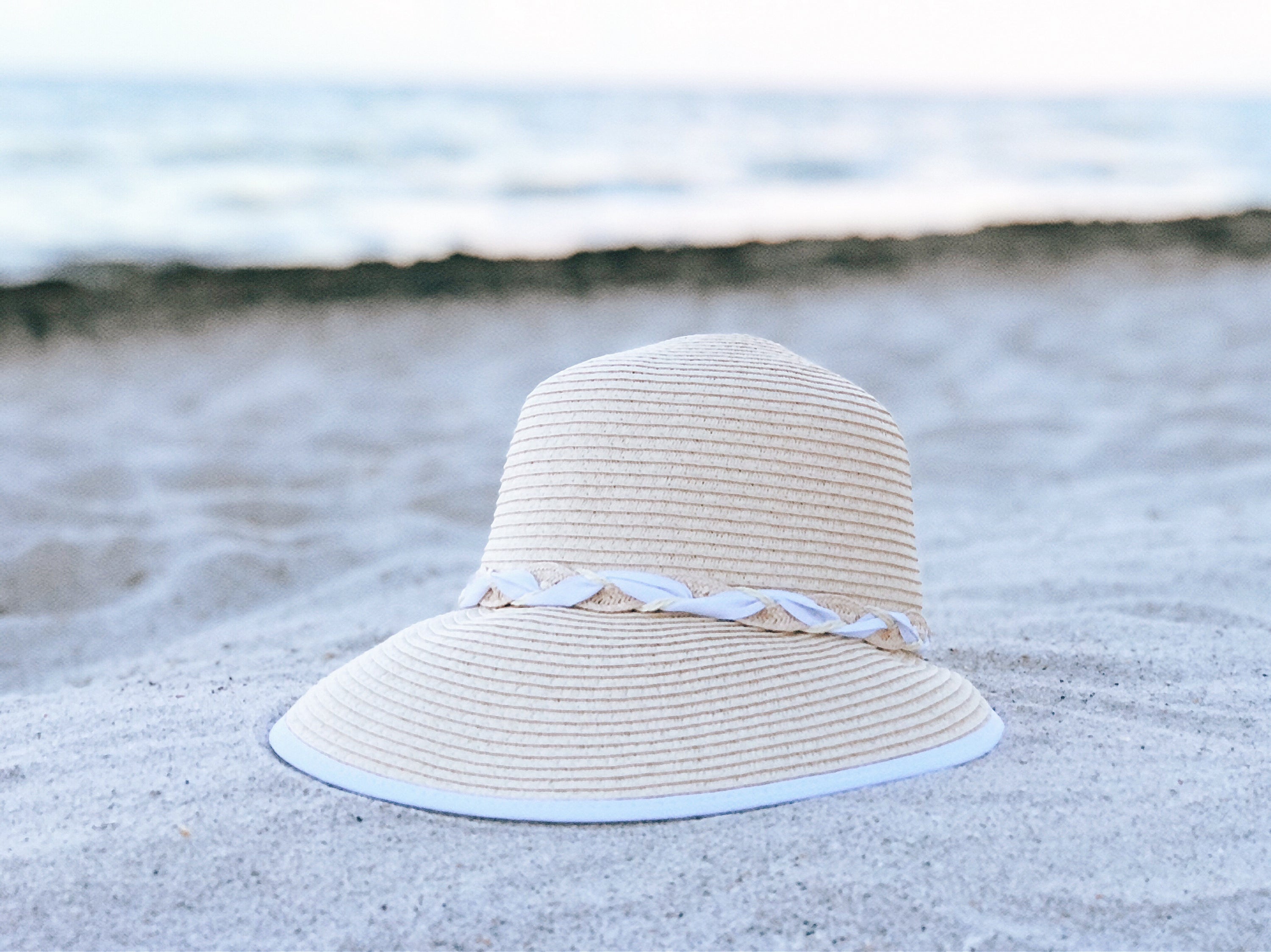 White summer visor with criss cross design and adjustable drawstring, perfect for sun protection.